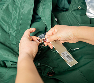 Workers are hanging logo tags to custom jackets