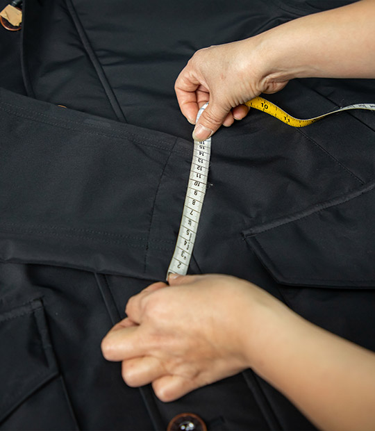 A worker is measuring the sizes of final products