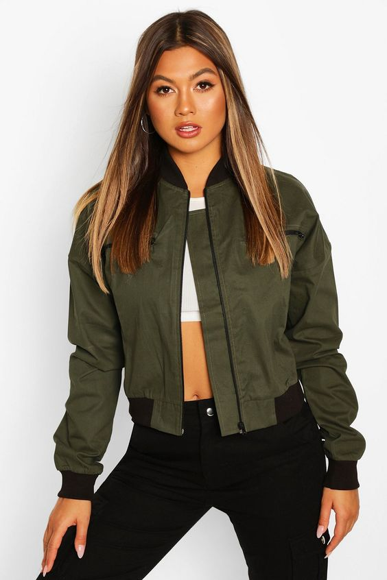 girl wearing green bomber jacket with ribbed collar, cuffs, and waistband